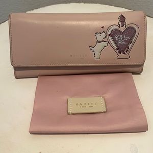 Super cute pale pink Radley London wallet w  duster. Print on front faded.